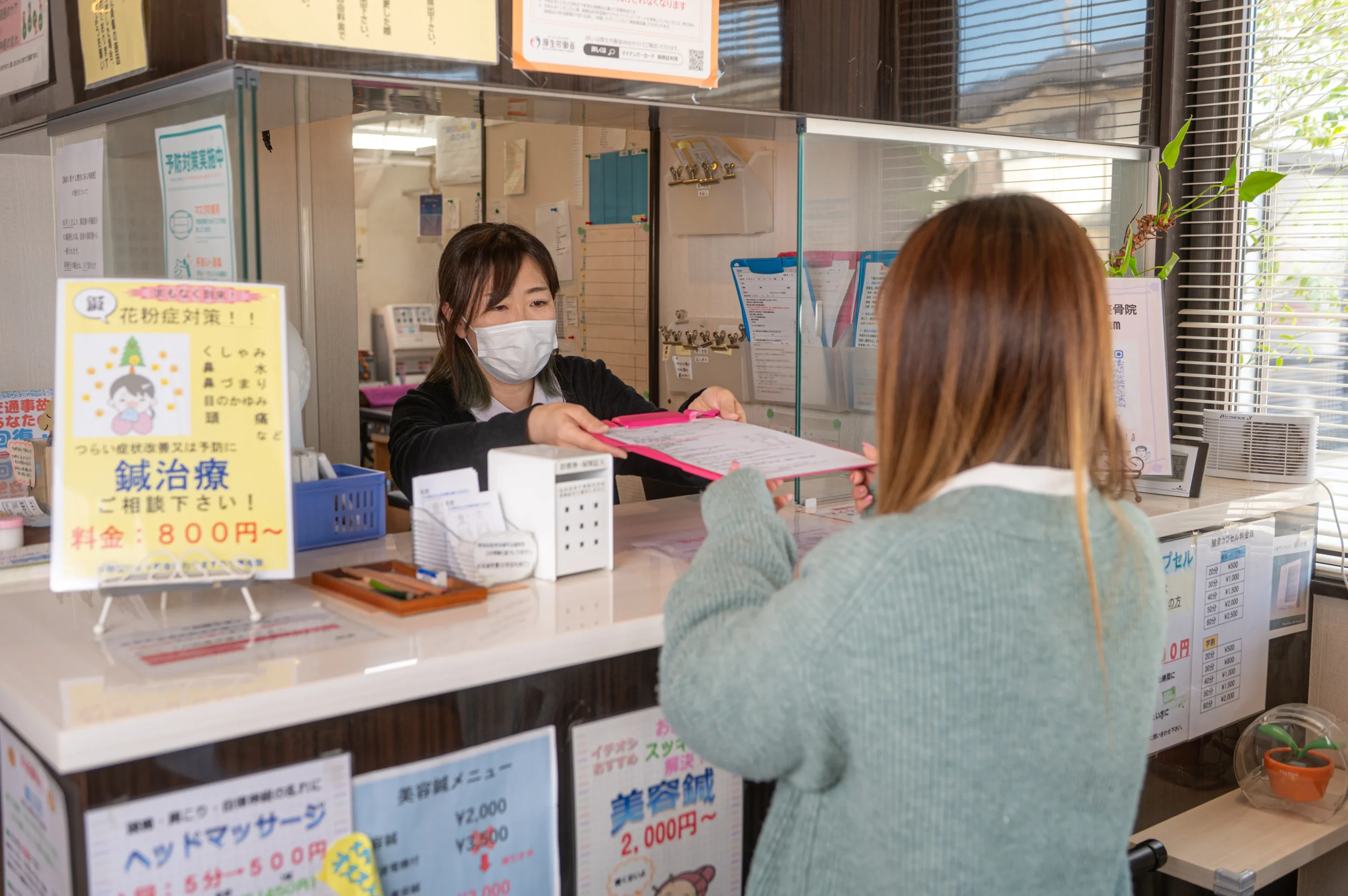 受付で問診票を受け取っている様子